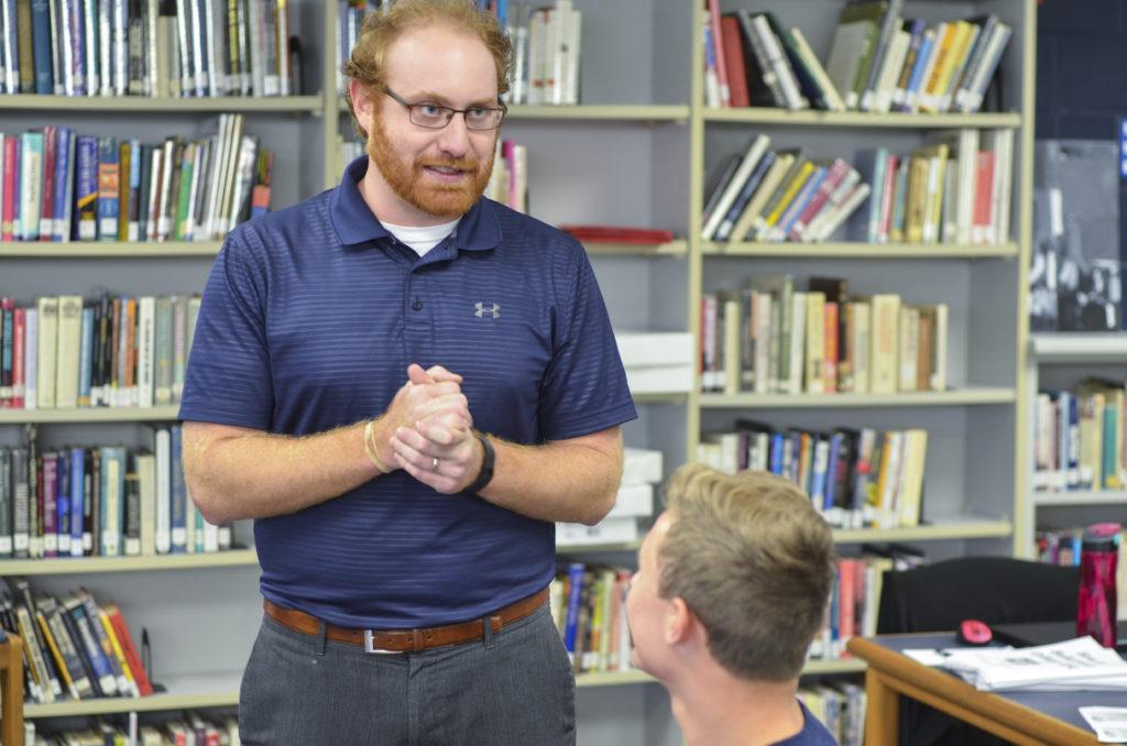 Cody Masters gives advice to a student in the library.