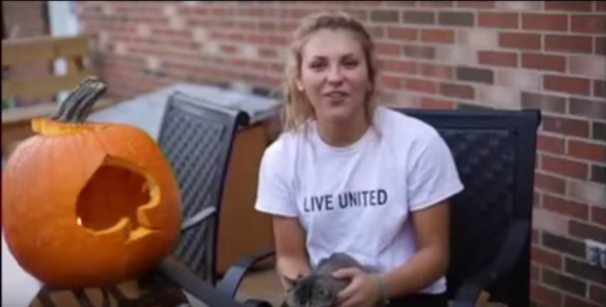 Sydney  Bednarski carves a blue ace pumpkin.