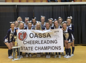 The Blue Aces competition cheer team holds up championship banner after winning the OASSA state title (Photo Courtesy of Granville Cheer Twitter).