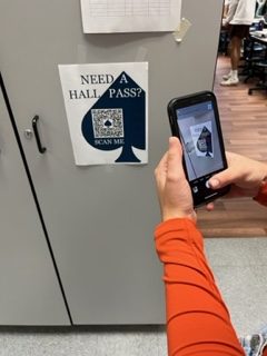 Senior Ella Kunar scans the hall pass QR code prior to leaving the room during Forensics. At the beginning of the school year, Principal Scott Hinton added a new hall pass system that requires students to fill out an online hall pass in order for them to leave classrooms.