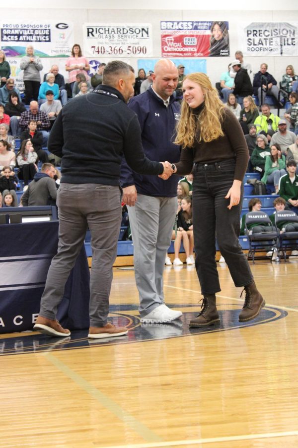 Sophie Cotts, a senior on the Cross Country team, shakes hands with Principal Hinton
