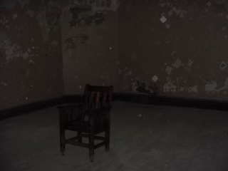 Orbs of ghosts can be seen around a rocking chair. This photo was taken in the wardens quarters. Photo by Dan Seckel used with permission.