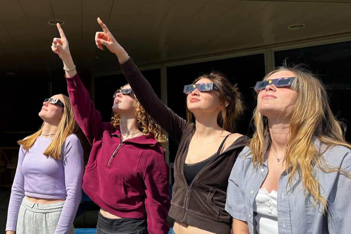 Lydia Sturgeon, Avery Ogg, Tessa Baker and Lyndy Van Horn test out eclipse glasses in anticipation of the Apr. 8 event.