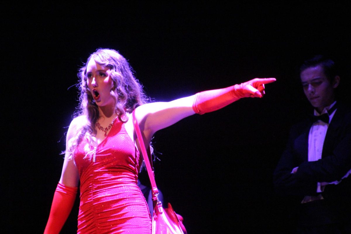 Miss Scarlet, played by Jordan York, points at who she believes to be the murderer. 