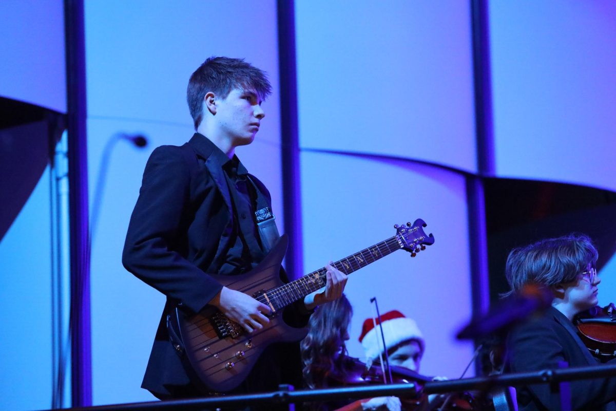 Junior Ben Mullett rocks out on the electric guitar during the orchestra's rendition of "Christmas Eve Sarajevo." The music department performed in holiday concerts Dec. 11-13.