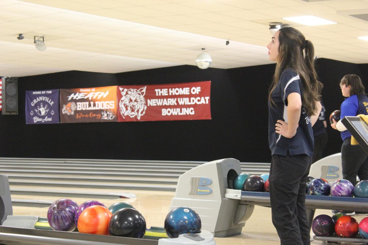 Freshman Maddie Wood checks the scoreboard before her turn to bowl. Learn more about Wood and the sport of bowling in the latest episode of "Gametime Laughs."