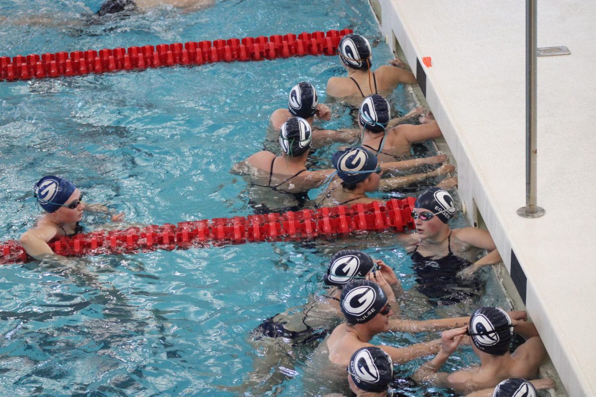 The swim team waits by the edge of the pool during warm-ups. Granville sets new records, brings home new trophies, and swimmers Lydia Sturgeon and Nolan Schneider are crowned LCL swimmers of the year. 