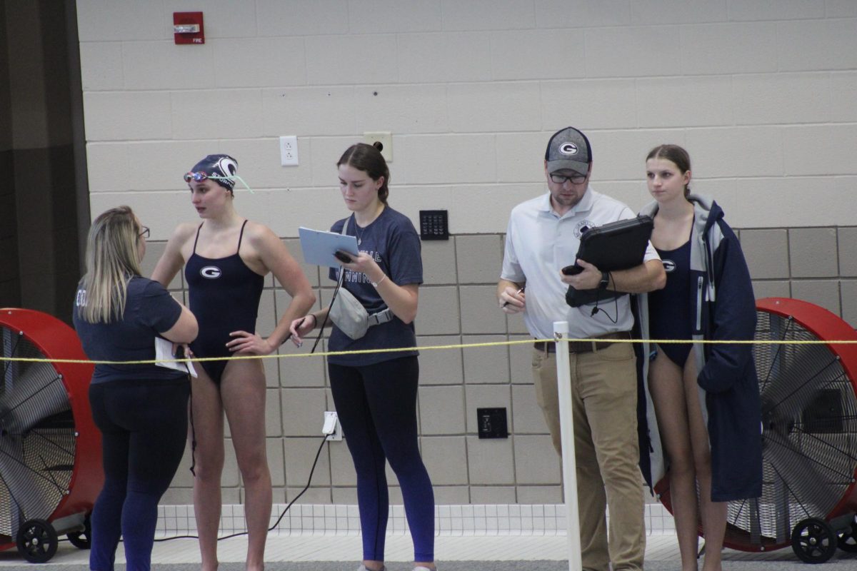 Lydia Sturgeon (12) and Sydney Eggert (11) meet with their coaches between events. Granville sets new records, brings home new trophies, and swimmers Lydia Sturgeon and Nolan Schneider are crowned LCL swimmers of the year. 