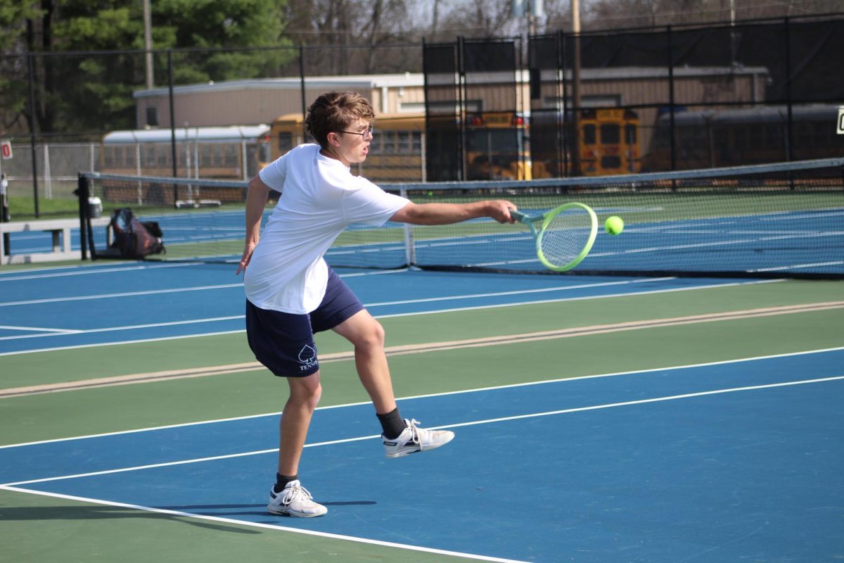 Owen White reaches for the ball in a doubles match against Watkins.