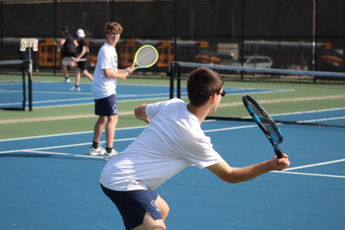 Benjamin Prokop reaches for the ball while his doubles partner Owen White watches with worry. 