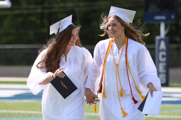 Twins Malana and Lydia Sturgeon walk hand-in-hand after receiving their diplomas.