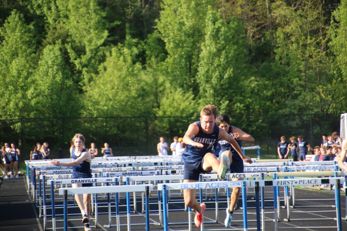 Jackson Haller (12) runs and wins the 100m Hurdles