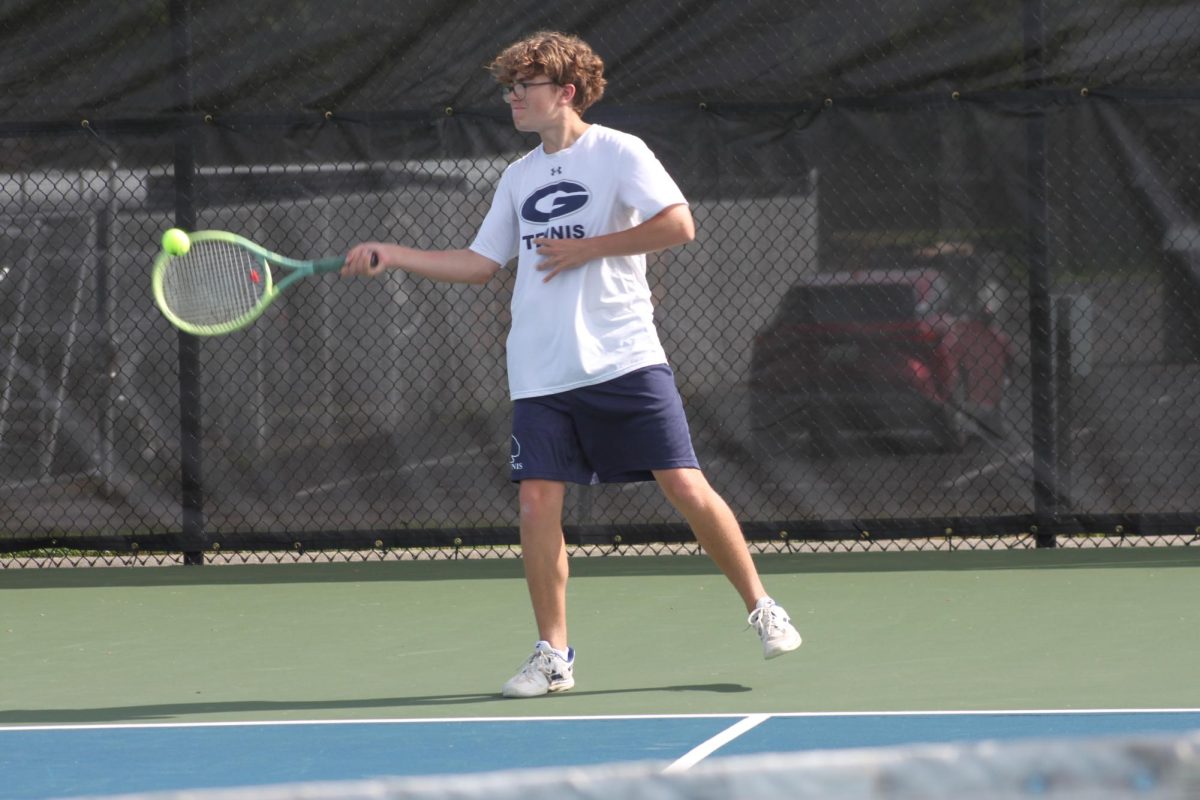 Owen White (11) whips his body around in mid-air to hit a fast forehand.