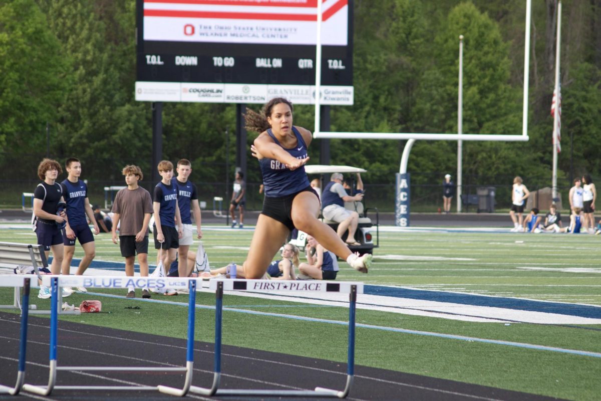 Last one, best one. Nora Carrington (12) leaps over her last hurdle of the 300m hurdles at the dual meet on April 30. Carrington is the 2024 indoor track and field state champion in triple jump. 