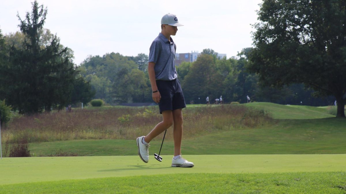 Freshman Hudson Hall walks towards the hole after he putts his ball.