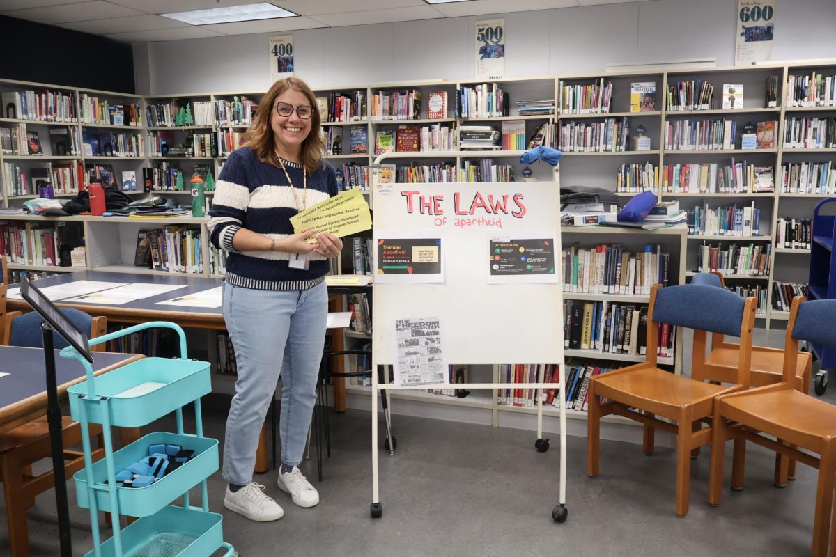 Mrs. Garee poses in front of the "Laws of apartheid" that's Mrs. Henderson's class is working on. 