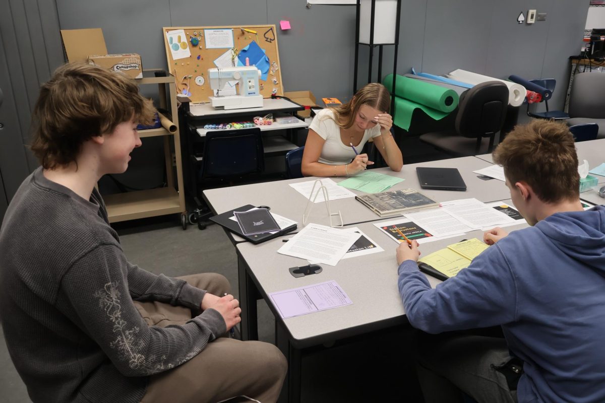Alex Bukala (10), Christian Hansen (10), and Mackenzie Hadley (10) group up to talk over the activity.