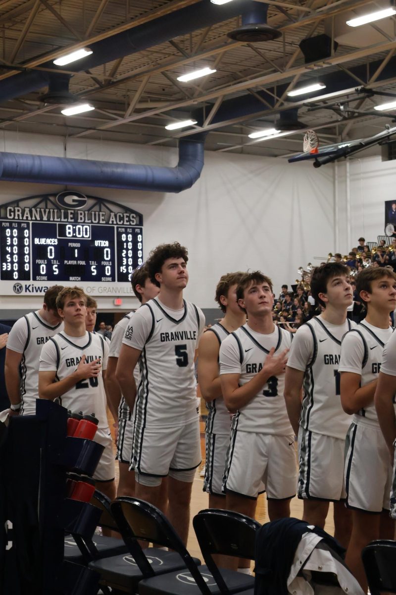 The team stands at attention as the national anthem echoes through the gym. Tension filled the air just minutes before the game began.