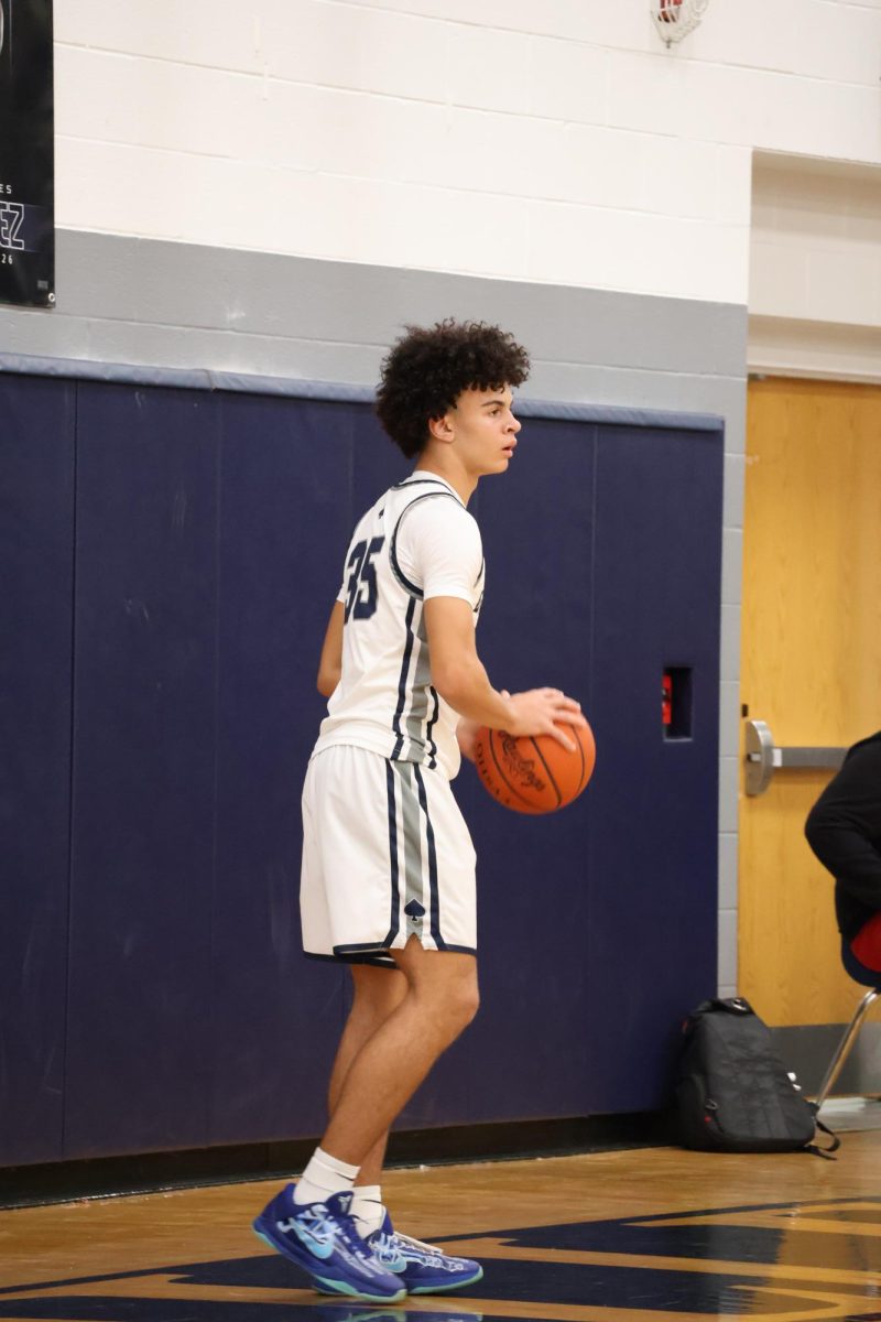 Freshman Carter Rhyan scans the court, looking for an open teammate and a passing lane. The Blue Aces pushed the pace with a fast, high-speed offense throughout the game.