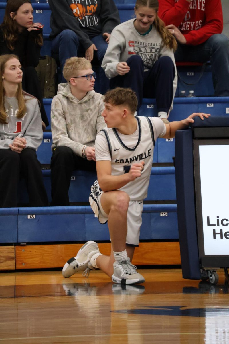 Senior Landon Goss crouches at the scorer’s table, waiting for the next whistle to enter the game. His teammates relied on his constant effort and reliability throughout the game.
