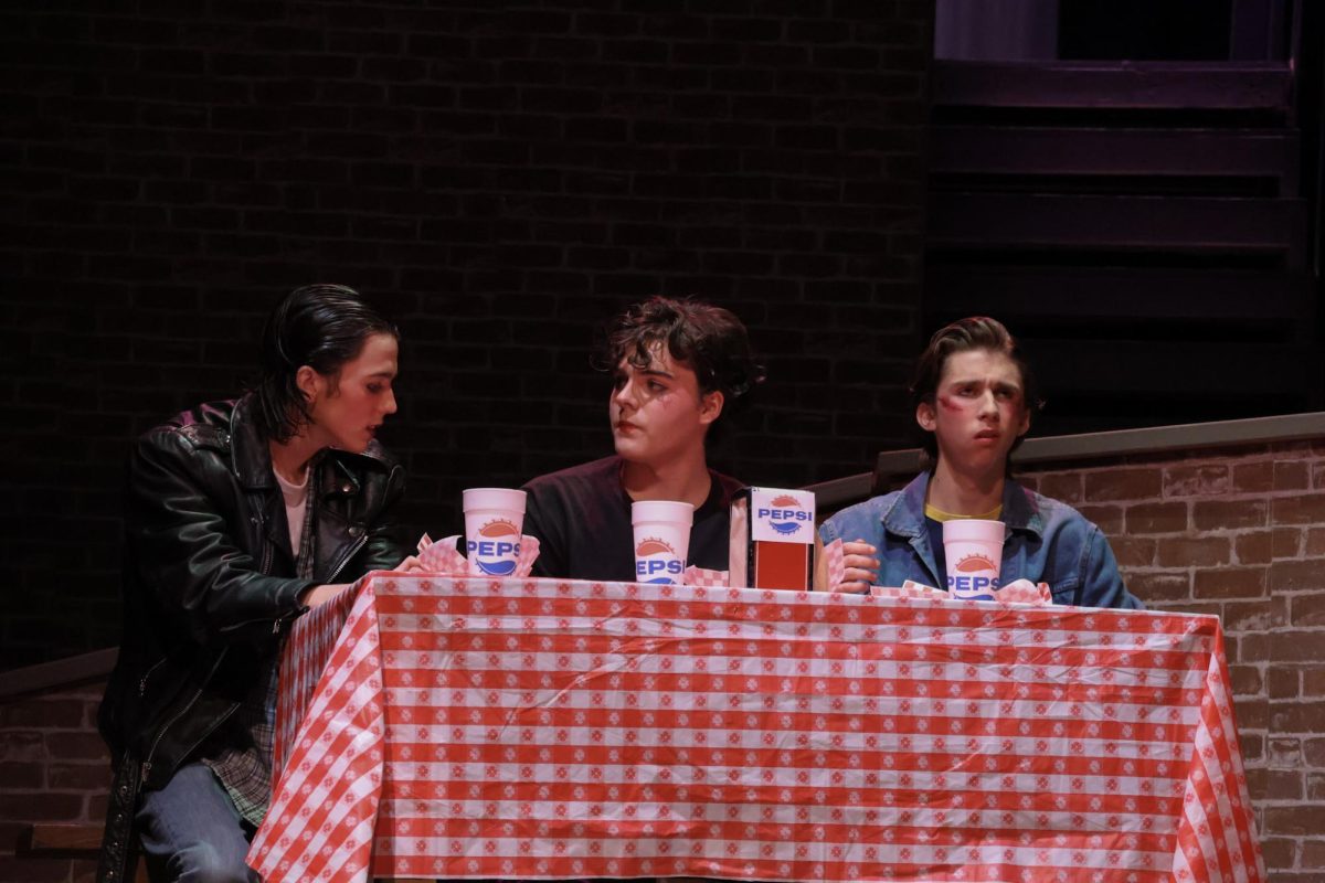 Ponyboy (Sam Hannig), Johnny (Maximilian Holtsberry), and Dallas (Jacob King), enjoying their food during Dairy Queen scene. 