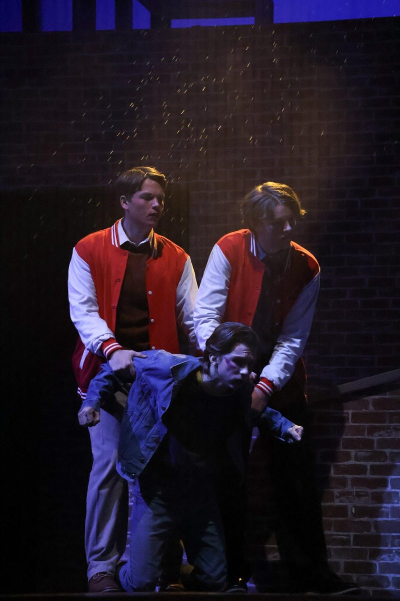 Randy (Zach Schilling), accompanied by Soc (Charlie Jordan), holding back Johnny (Maximilian Holtsberry) during fight scene. 