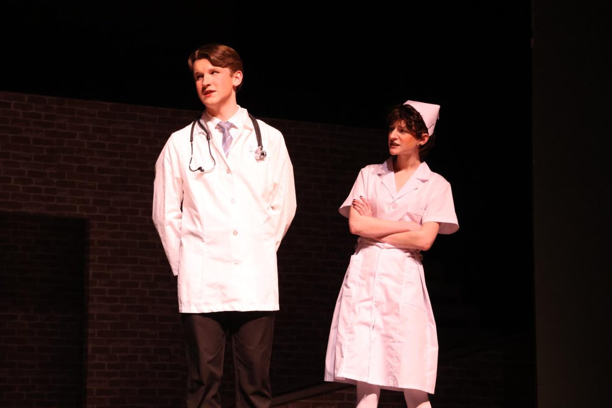 The doctor (Jacob Campbell) and Nurse (Elliott Smith) talk to Johnny's family about his injuries. 