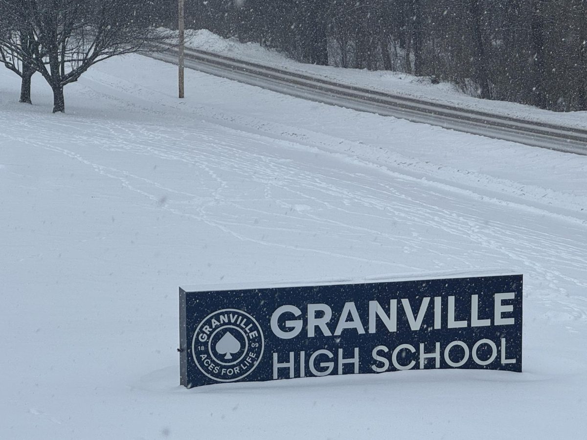 The Granville High School sign peeks out of the snow on a winter day.