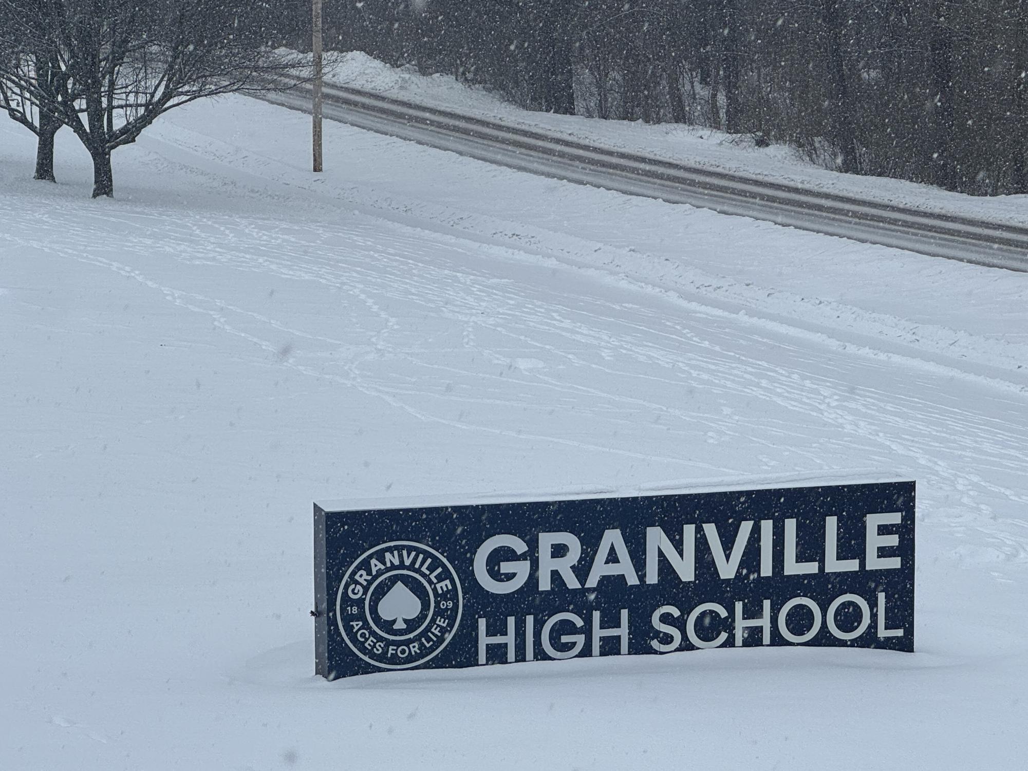 The Granville High School sign peeks out of the snow on a winter day.