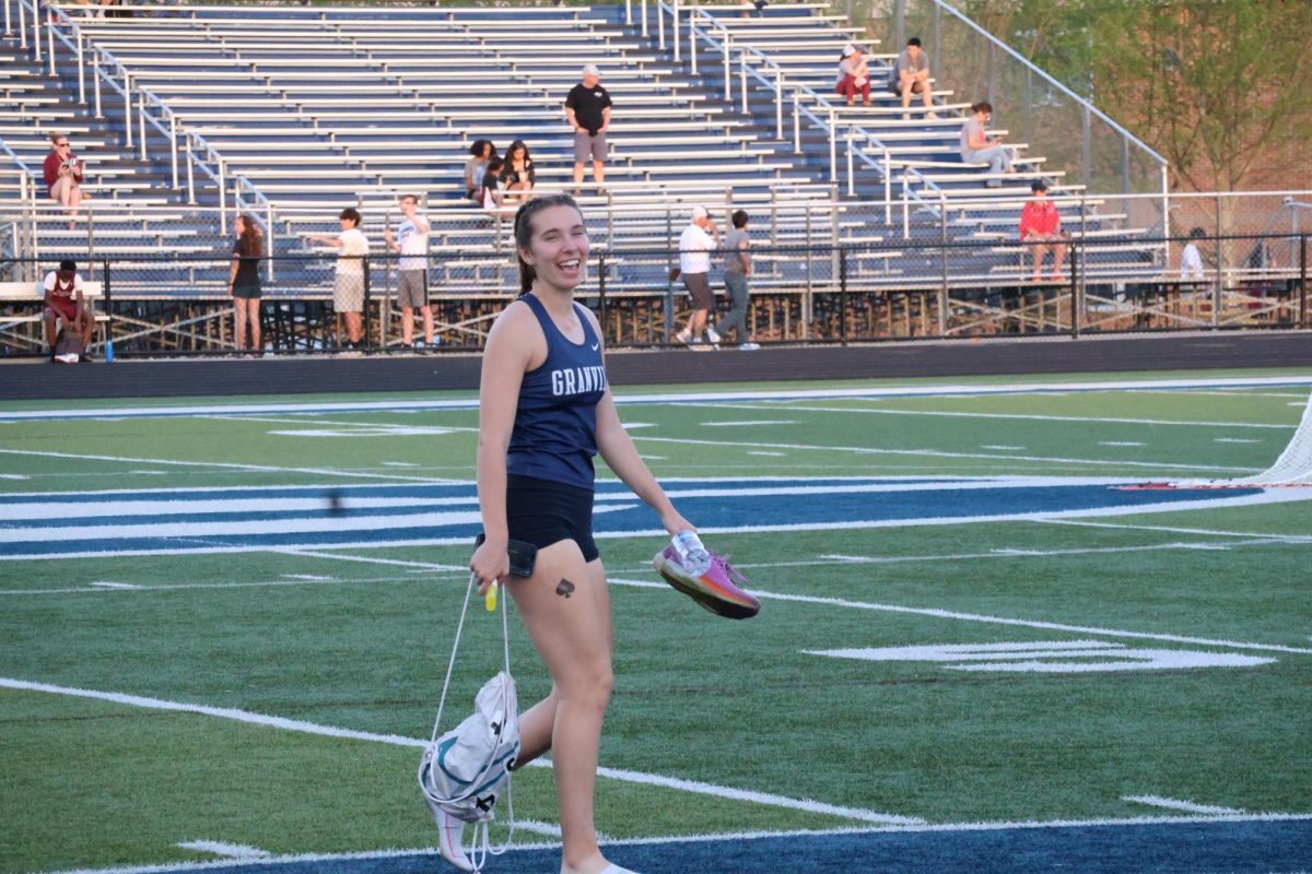 Senior Audrey Ames smiles after her race. She competed in the hurdles and ran fast. 