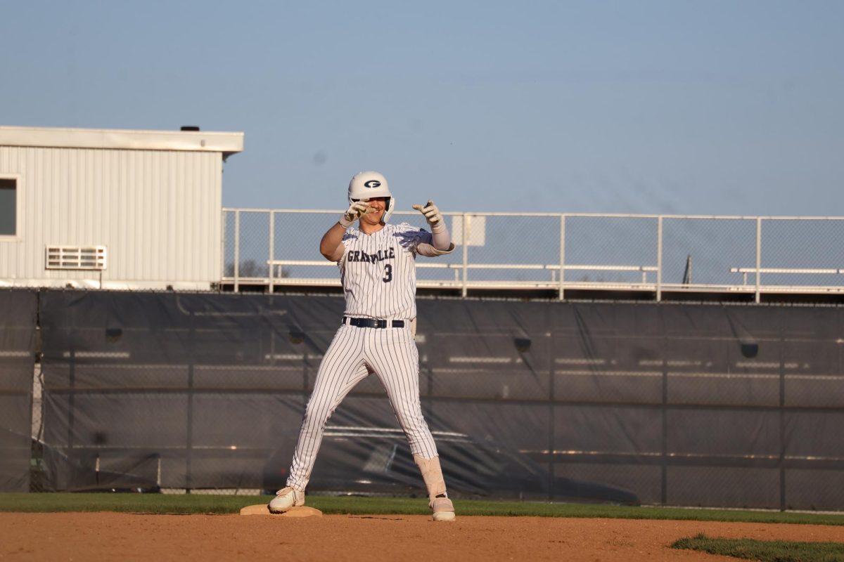 Patrick Acton (12) stands on second, fired up after his double. He celebrates with energy, ready for what comes next. 