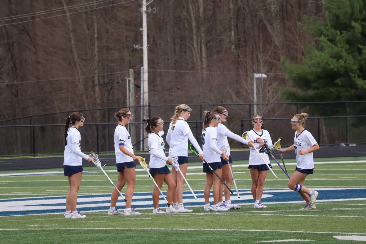 Senior Ellie Brower runs across the field getting ready to play. The team gave her high fives to pump her up.