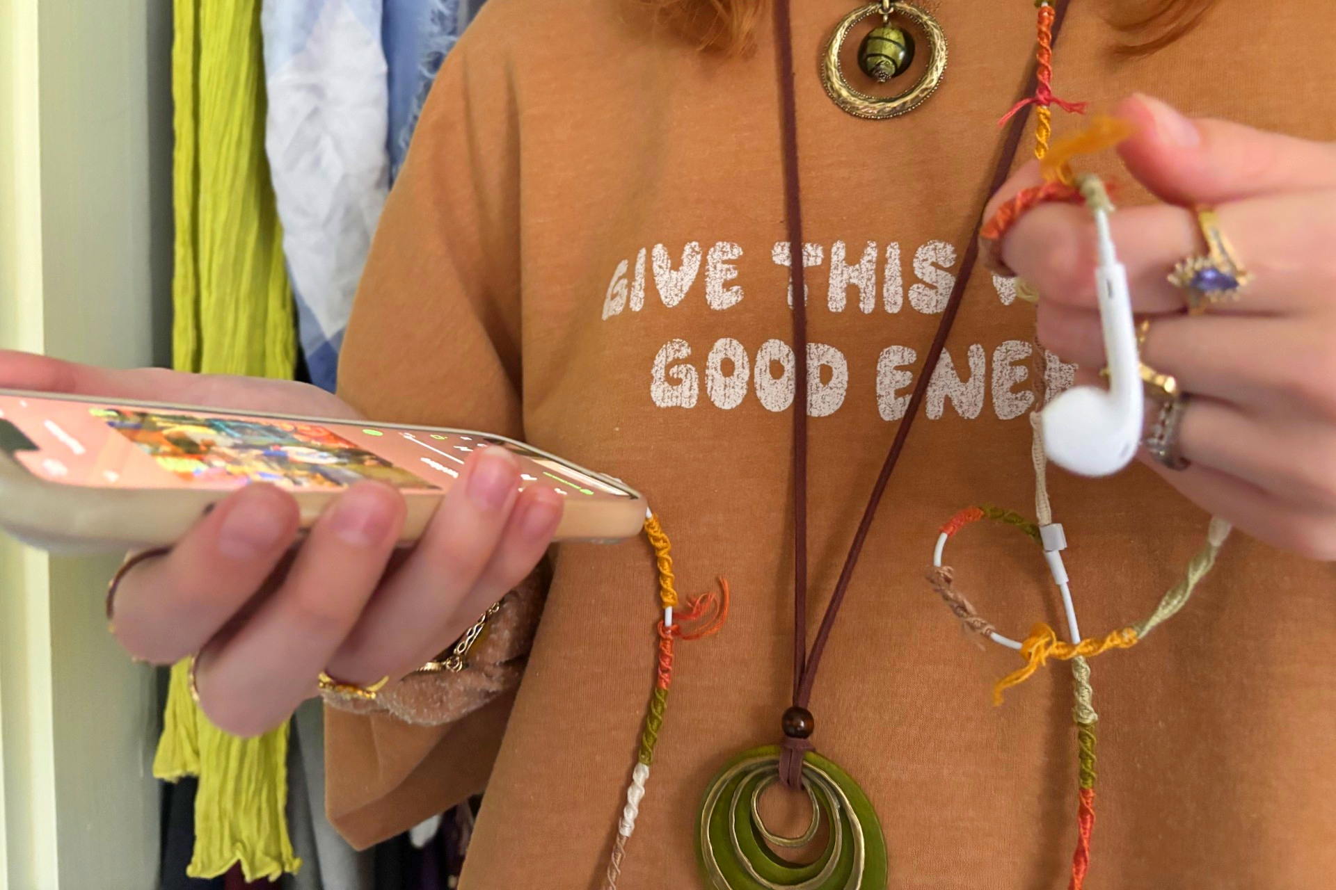 Hannah Lisk listening to music with her wired headphones. She has wrapped her headphones in embroidery thread.